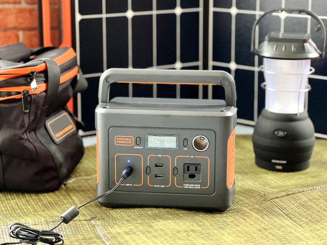充電中のポータブル電源とソーラーパネルとケースとライト