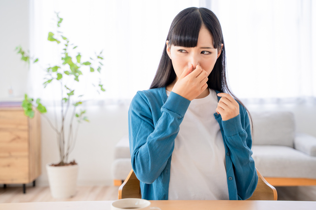 ニオイを気にして鼻をつまむ女性