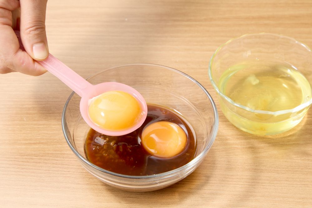 卵黄を生姜醤油麹に入れるところ