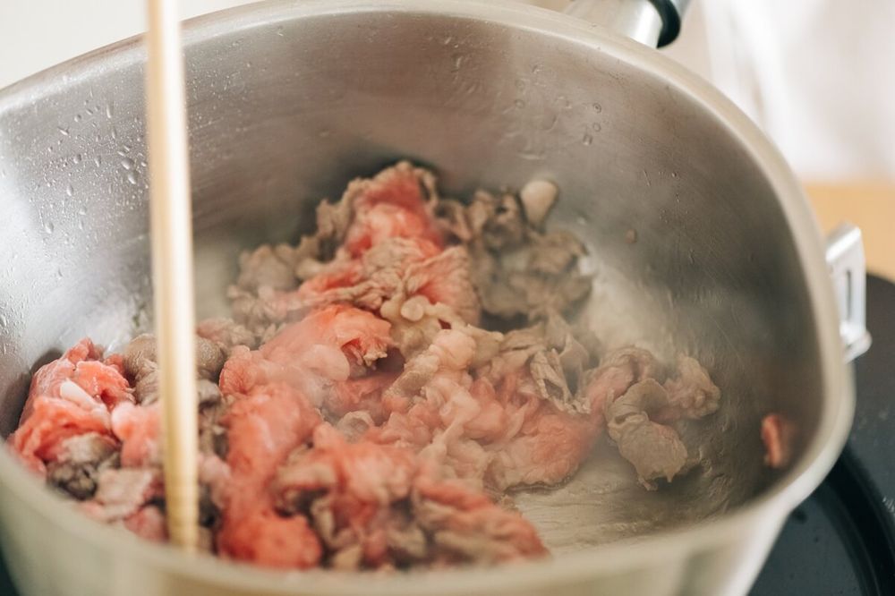 鍋で肉を炒める