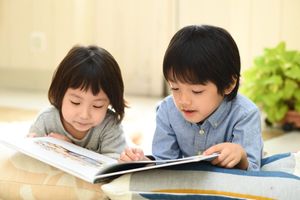 絵本をよんでいる兄妹