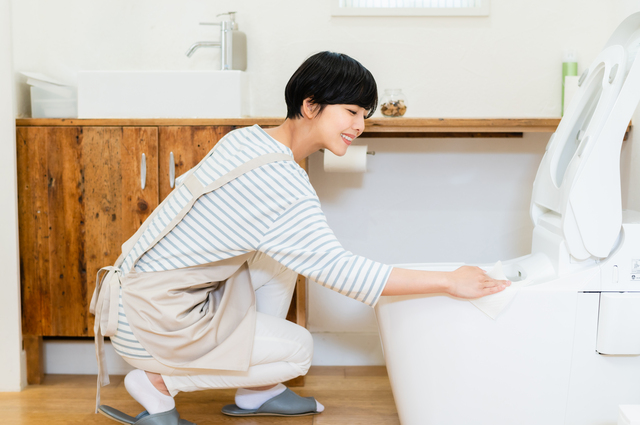 トイレを掃除する若い女性