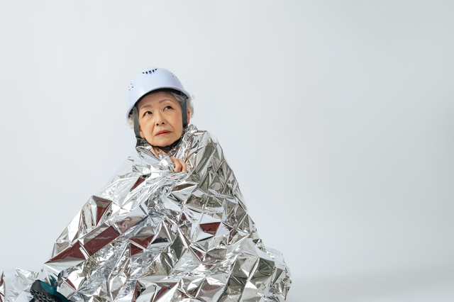 サバイバルシートに包まるシニア女性