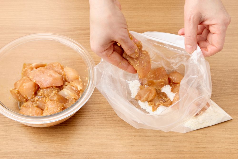 醤油麹唐揚げを粉の袋に入れる