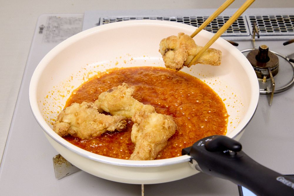 ヤンニョムソースに唐揚げを絡めているところ